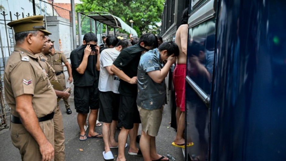Prison guards escort detained Chinese nationals suspected of running cyberscams in Sri Lanka
