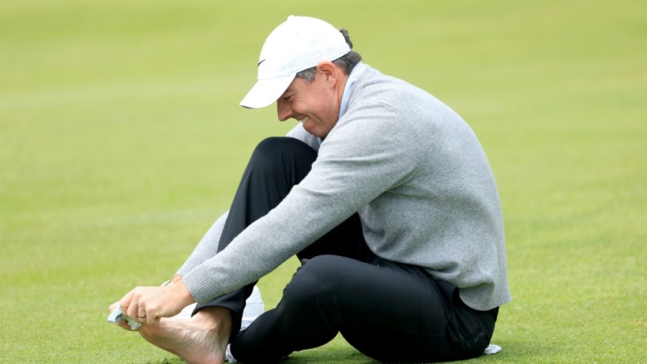 Second-ranked Rory McIlroy of Northern Ireland checks on a blister on his right pinky toe on the 18th hole during a practice round on the eve of the opening round of the PGA Championship at Aronimink