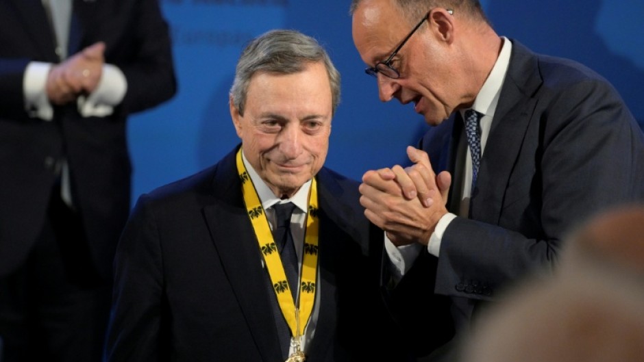 German Chancellor Friedrich Merz, rights, congratulates former European Central Bank president Mario Draghi on winning the 2026 Charlemagne Prize