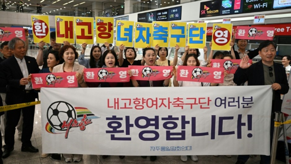 South Korean activists hold banners welcoming North Korea's Naegohyang Women's FC at Incheon International Airport