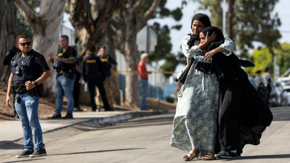 Two women react following a shooting at the Islamic Center of San Diego, in southern California, on May 18, 2026 that left three people dead