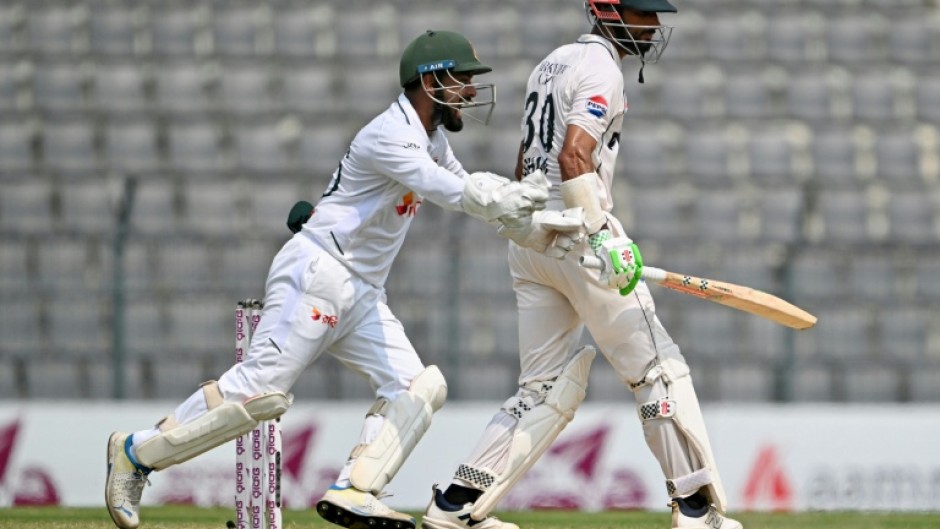 Bangladesh's Litton Das (L) celebrates after the dismissal of Pakistan captain Shan Masood (R)