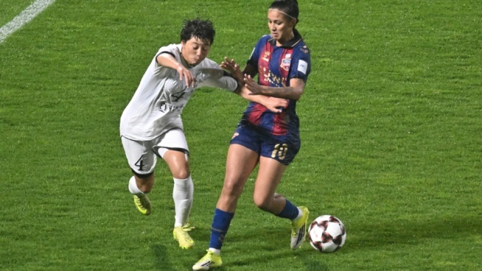 North Korea's Naegohyang Women's FC defender Ri Myong Gum (left) vies for the ball with South Korea's Suwon FC Women forward Mileninha Barreto de Oliveira during their Women's Asian Champions League semi-final at Suwon Sports Complex