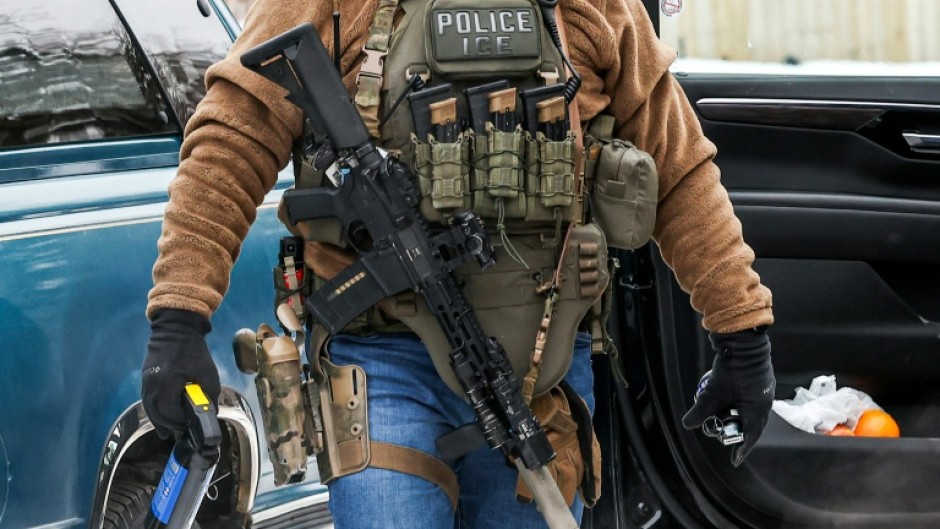 A masked federal agent from Immigration and Customs Enforcement (ICE) patrols in Minneapolis, Minnesota, in February 2026