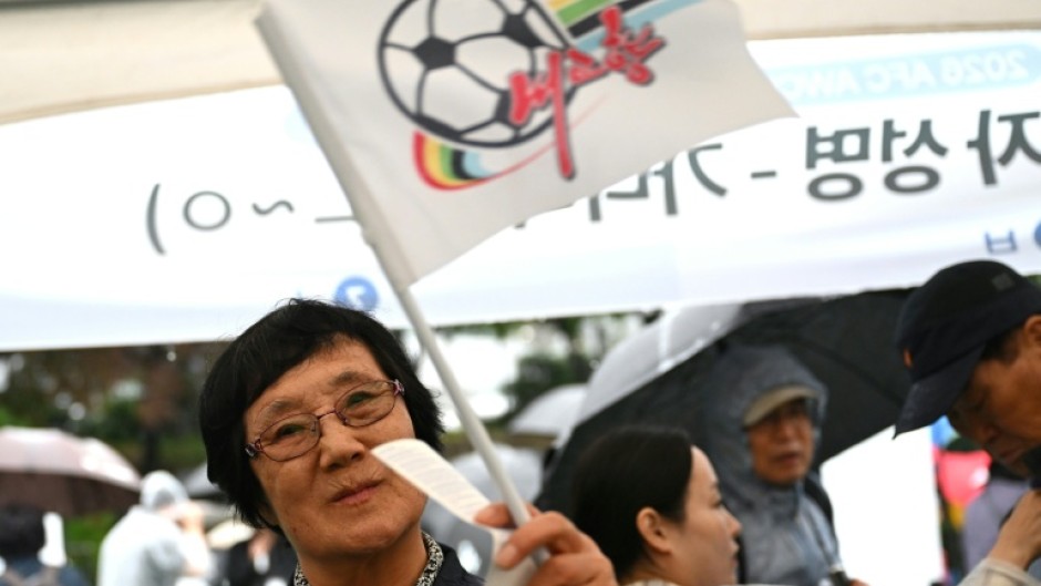 A South Korean football supporter waves a flag of North Korean team Naegohyang Women's FC