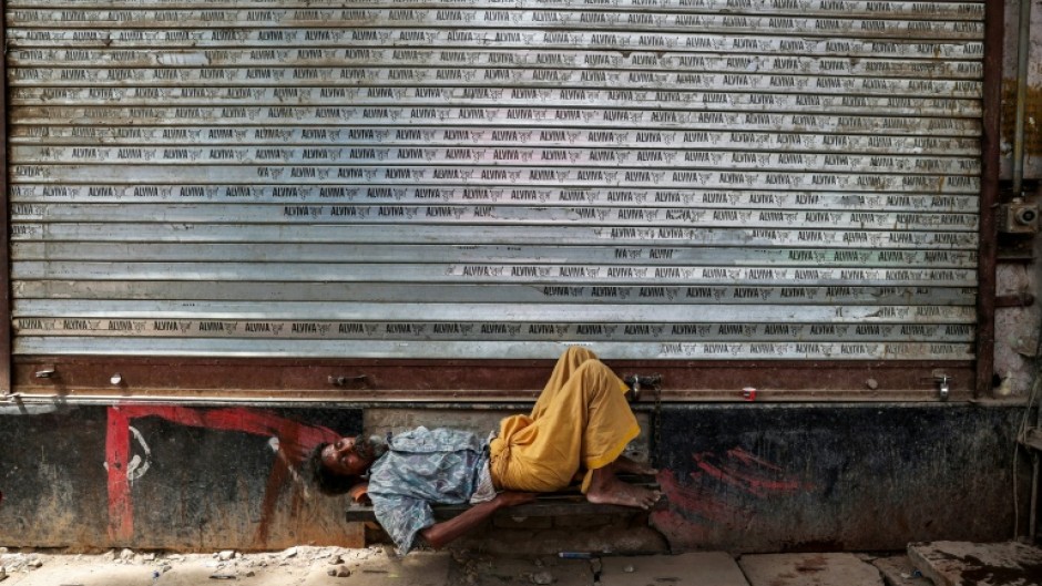 A man takes a nap in front of a closed shop on a hot summer day in Varanasi, in India's Uttar Pradesh, on May 23, 2026