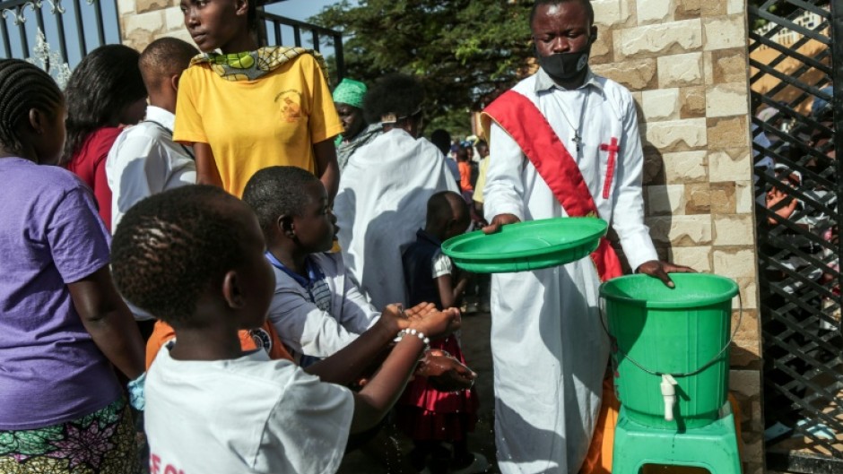 Parishioners wash their hands before entering church as their region battles an Ebola outbreak which has killed more than 200 people
