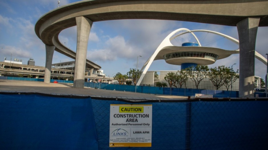 A closed construction area is seen near The SkyLink Automated People Mover line and the Theme Building and Air Traffic Control Tower at Los Angeles International Airport