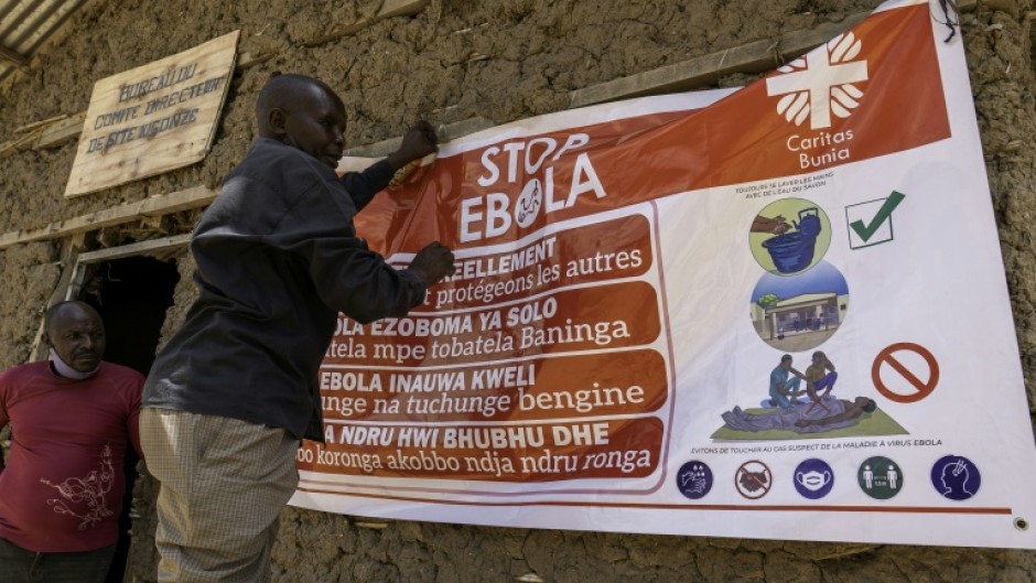 A man hangs an Ebola awareness banner in the Kigonze displaced persons camp in Bunia, in the eastern DRC