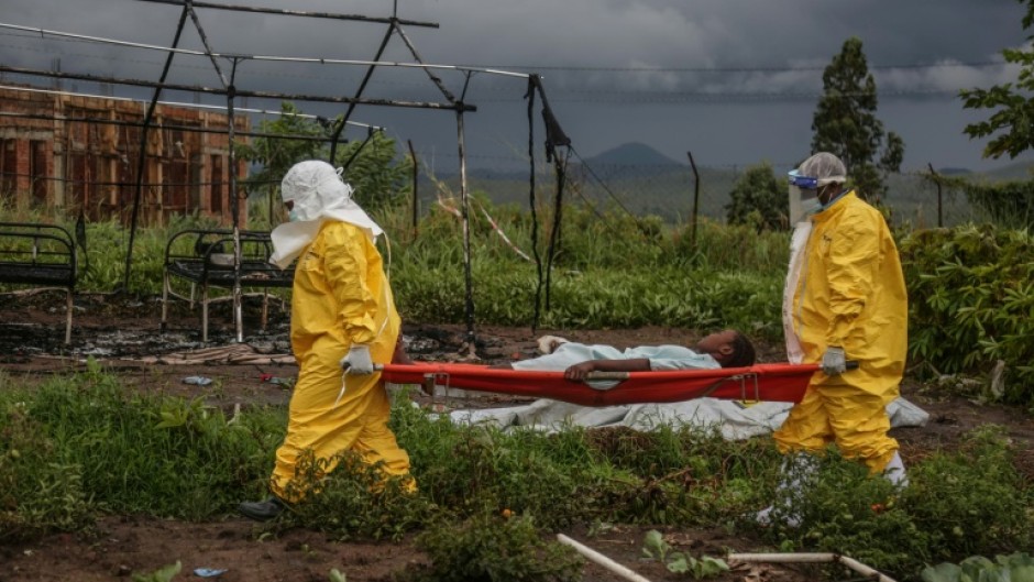 Medical staff carry an Ebola patient on a stretcher at Rwampara hospital in DR Congo