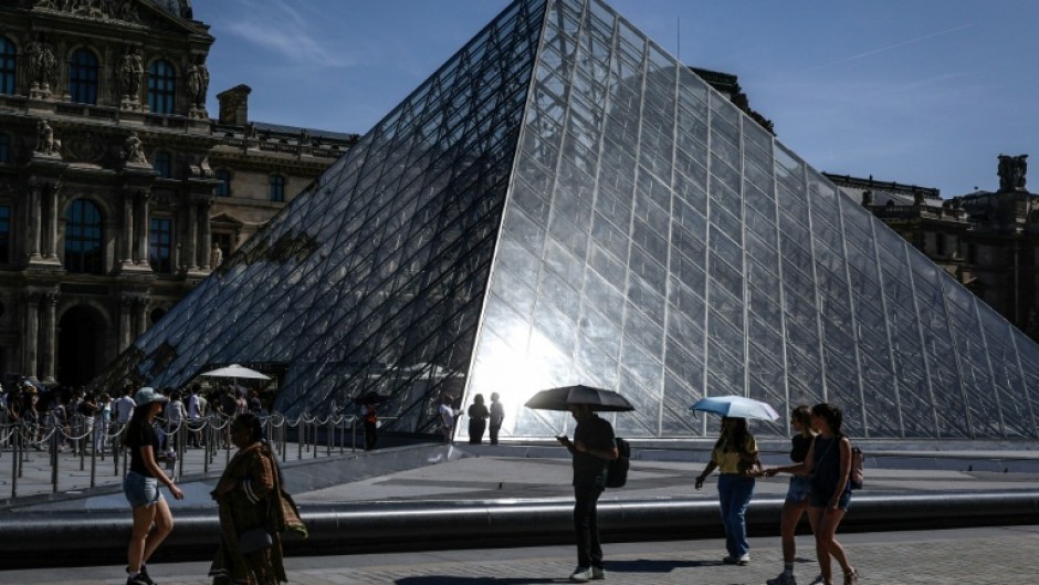 The record spring heatwave in France left tourists at the Louvre sheltering from the sun under umbrellas