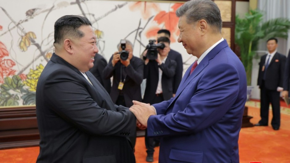 (FILES) This picture taken on September 4, 2025 and released from North Korea's official Korean Central News Agency (KCNA) on September 5, 2025 shows North Korean leader Kim Jong Un (L) shaking hands with Chinese President Xi Jinping in Beijing