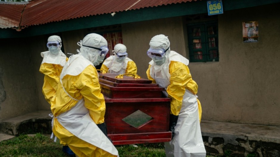 Members of a Congolese Red Cross team carry the coffin of a woman suspected of having died from Ebola in the eastern city of Bunia