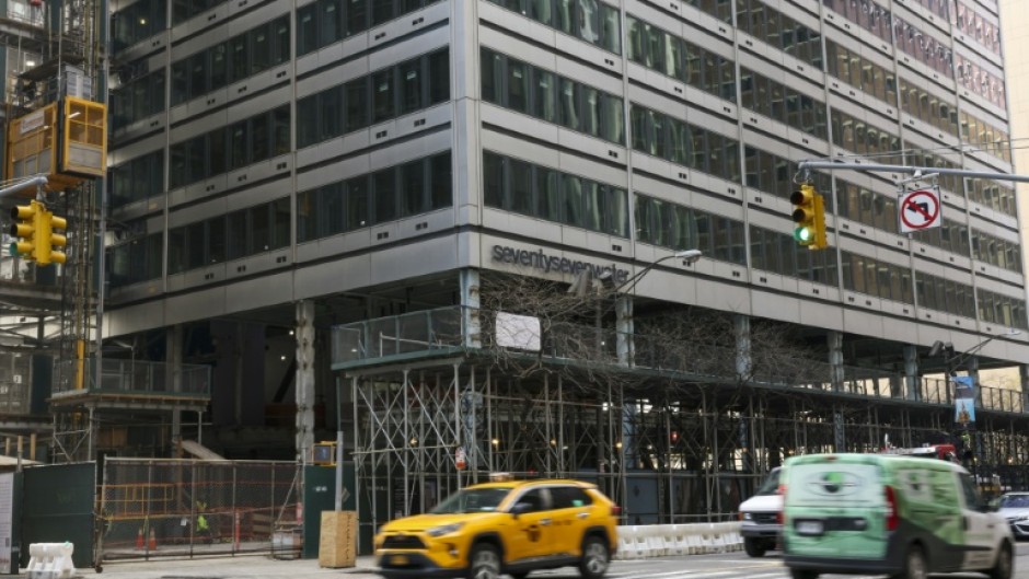 Cars drive past 77 Water Street, a former office building being transformed into luxury rental apartments in the Financial District of New York in April 2026