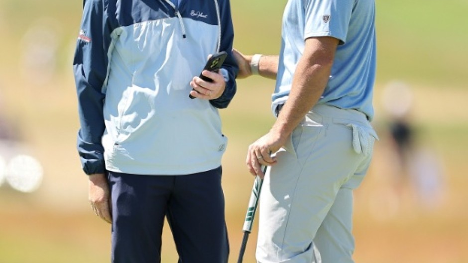World number two Rory McIlroy, right, speaks with coach Phil Kenyon during a practice round ahead of the 126th US Open at Shinnecock