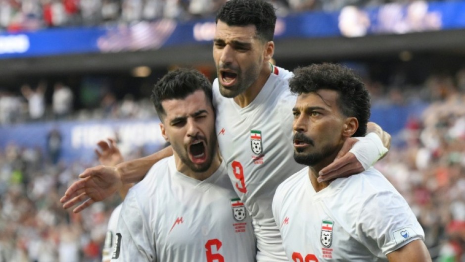 Iran players celebrate after scoring during their first World Cup match, a 2-2 draw against New Zealand in Los Angeles
