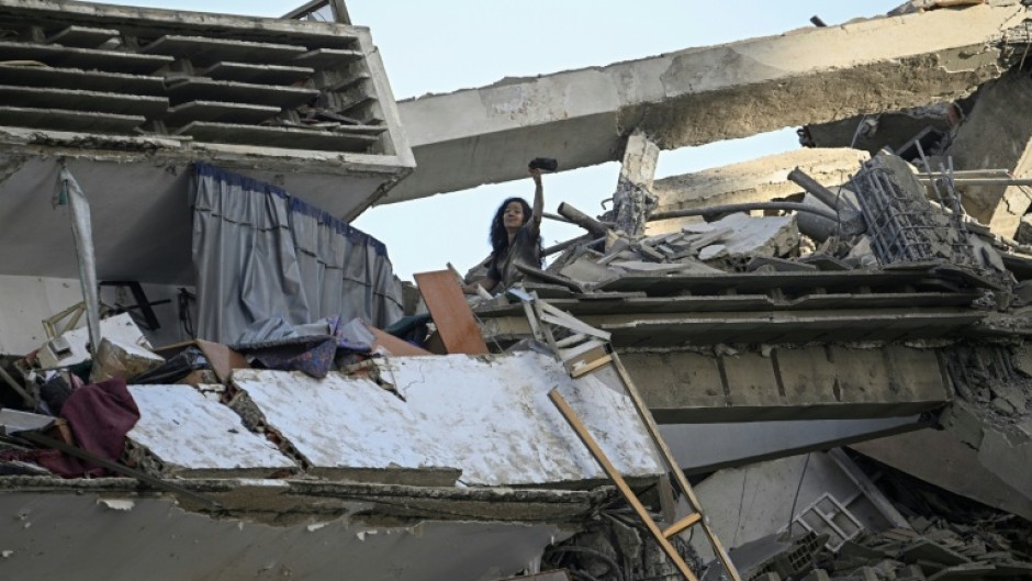 A woman gestures for help atop an apartment building following the earthquakes that hit Venezuela's La Guaira state particularly hard