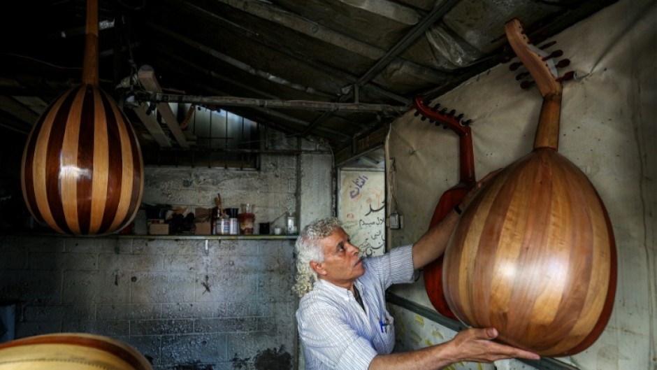 Displaced Palestinian craftsman Suhail Abu Shawish repairs damaged Ouds at a workship in Nuseirat refugee camp in Gaza