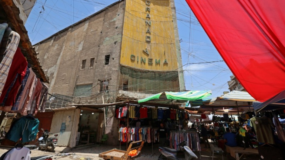 Street vendors gather outside the faded facade of the Granada Cinema, an early 1940s landmark, in the Bab al-Sharqi district of central Baghdad