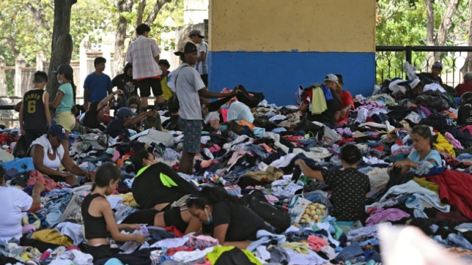 People sift through clothing at a donation center in Caraballeda, La Guaira state