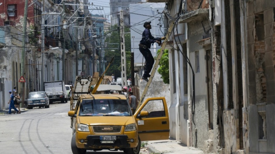 An electrician works on the power grid in Havana during a nationwide power outage in Cuba, the third in six months