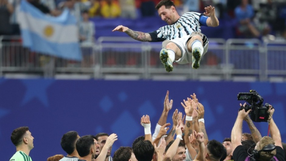 Argentina forward Lionel Messi is tossed into the air by team-mates after inspiring a late fightback in a 3-2 victory over Egypt