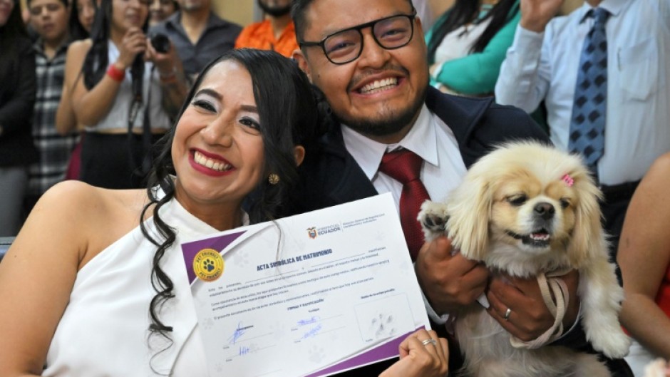 Diana Tupiza and Andres Alquinga pose with their dog Luna, who served as a "witness" at their civil wedding and stamped the marriage certificate with her paw print