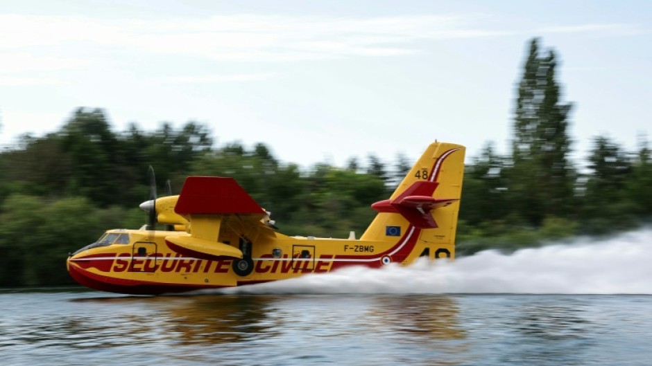 A firefighting plane scooped up water from the Seine river to douse the fire in Fontainebleau forest southeast of Paris