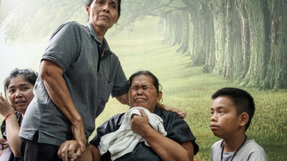 Relatives of victims of the fire waiting at the Police General Hospital in Bangkok on July 14