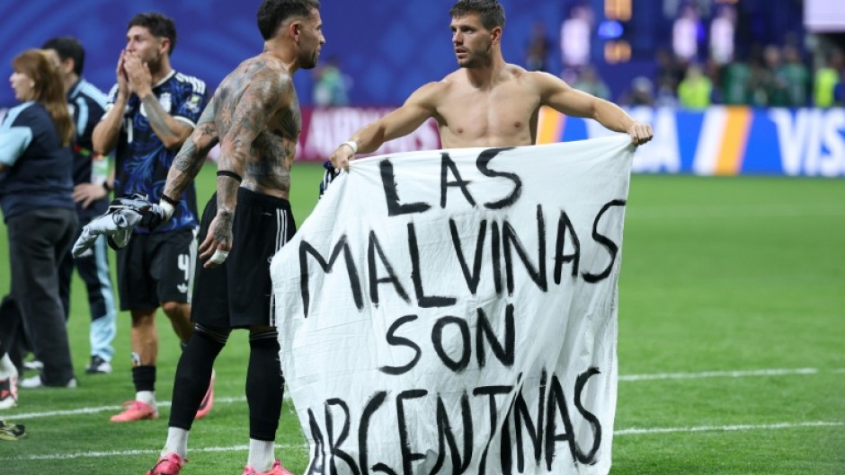 Argentina players hold up a banner saying 'The Malvinas (Falkland Islands) are Argentine'