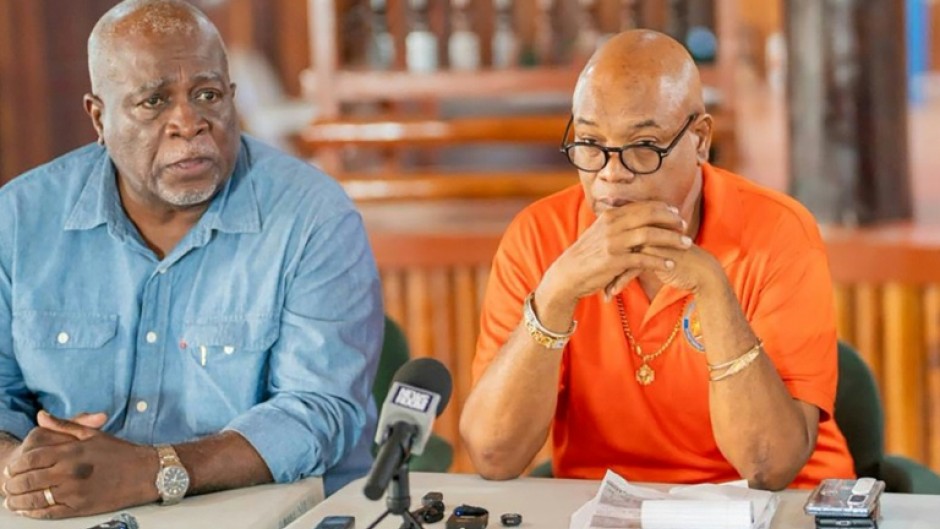Guyana's Prime Minister Mark Phillips (L) and Minister of Public Works Juan Edghill (R) speak at a press conference after a ferry disaster