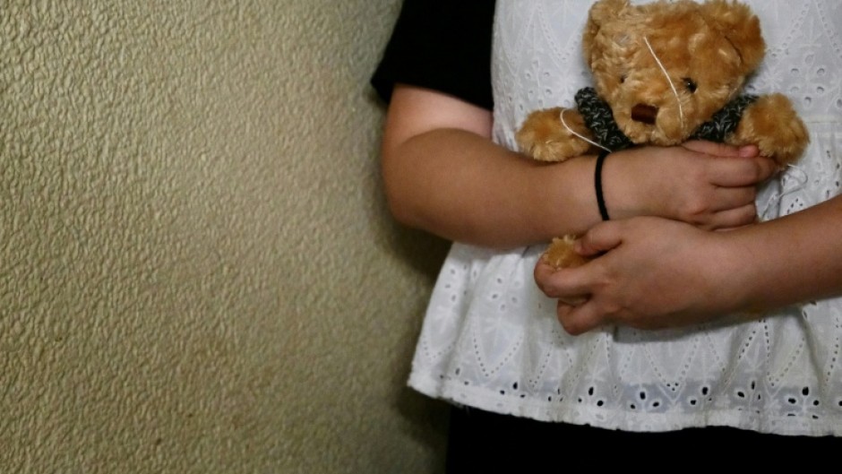 Bobo a woman who suffered persistent child sexual abuse for several years, holds a teddy bear