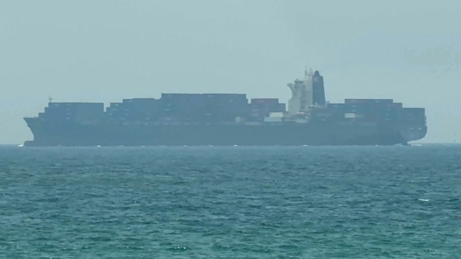 This frame grab taken from AFPTV video footage on July 12, 2026 shows a cargo ship anchoring near the Strait of Hormuz off the eastern coast of the United Arab Emirates at Khor Fakkan