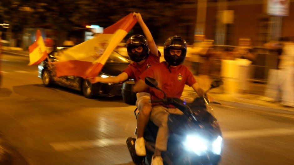 Spain supporters on a motorcycle wave the flag celebrating victory after the 2026 World Cup final