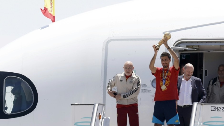 Spain's captain Rodri holds up the World Cup trophy after the team returned to Madrid