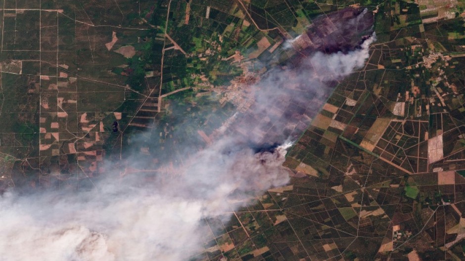 This handout satellite photograph taken on July 24, 2026 and released by 2026 Planet Labs PBC shows smoke rising from the wildfire in Le Porge and Lege-Cap-Ferret in France