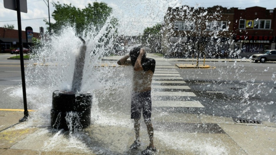 A person cools off with water from an open fire hydrant during a heat wave on the West Side of Chicago, Illinois; Human-caused climate change can amplify El Nino's associated effects because a warmer ocean and atmosphere increase the availability of energy and moisture for extreme weather events