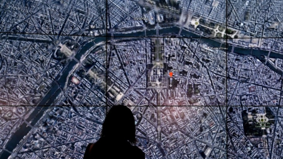 This April 18, 2017 file photo shows people viewing a Google Earth map of Paris, France at an event at New York's Whitney Museum of Art