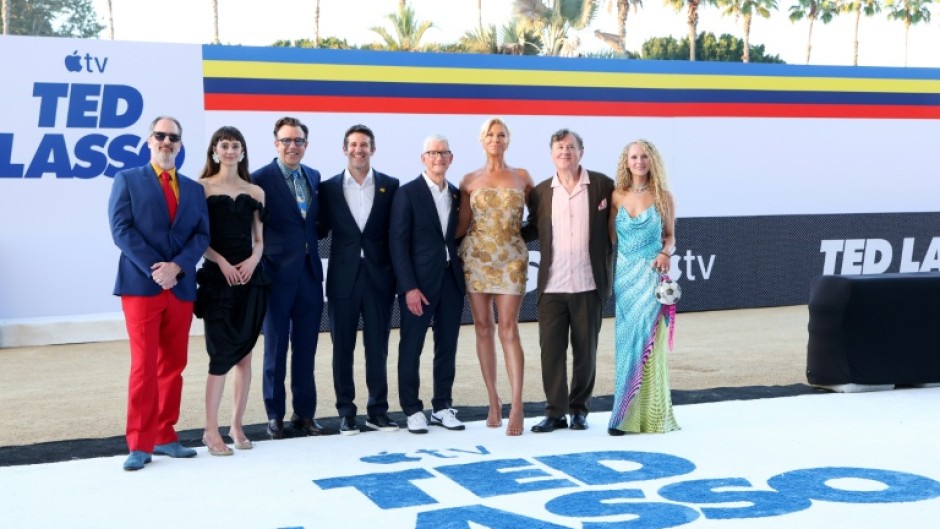 Stars of 'Ted Lasso' gather with Apple CEO Tim Cook at a Los Angeles premiere of the show's fourth season include (L-R): Brendan Hunt, Tanya Reynolds, Jason Sudeikis, John Ternus, Cook, Hannah Waddingham, Jeremy Swift and Juno Temple