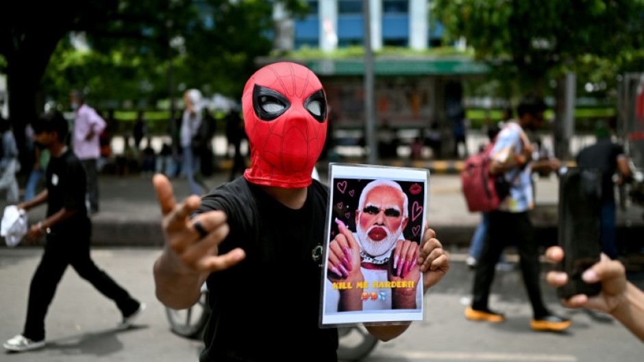 A Cockroach Janta Party supporter holds a doctored picture of India's Prime Minister Narendra Modi at a rally in New Delhi on July 25. Modi said he wanted to "forgive" protesters who abused him