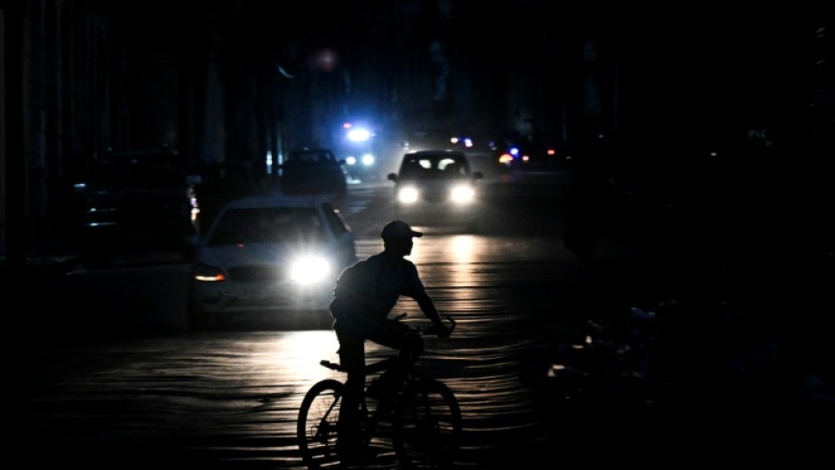 A man rides his bicycle down a street during a blackout in Havana