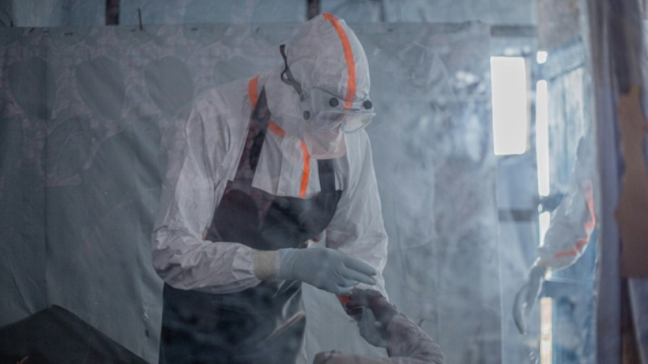 A doctor providing care to a patient with Ebola at a treatment centre in Bunia, capital of the DRC's Ituri province