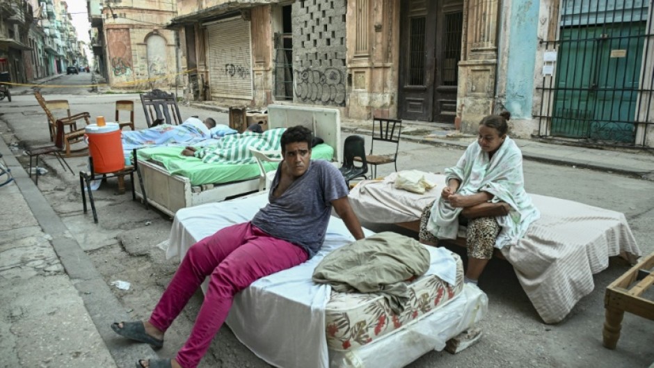 Sleeping out in the stifling summer heat leaves residents of a partially collapsed building exhausted
