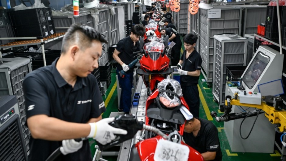 Workers assemble motorcycles at the ZXMoto factory in Chongqing, southwestern China