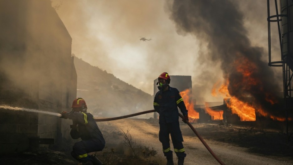 Firemen battling a blaze that broke out at a livestock facility near Kouvaras, south of Athens