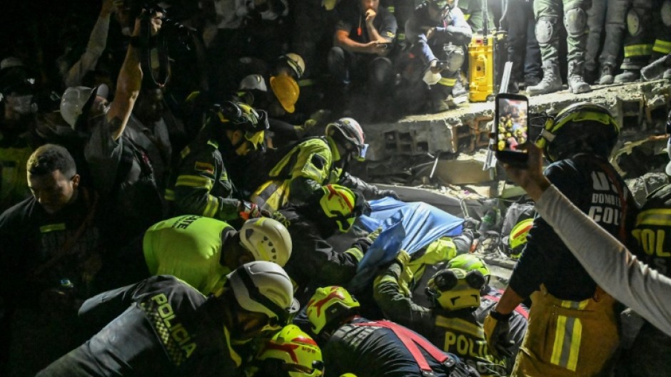 Firefighters and rescue teams carry survivor Daniela Largo from the rubble of a collapsed building after an earthquake in Pereira, Colombia