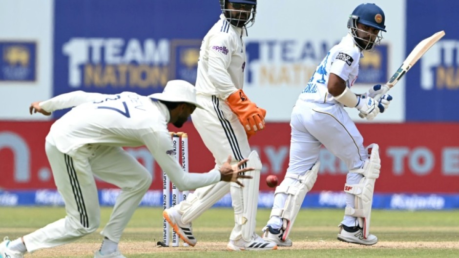 Sri Lanka's Sonal Dinusha (R) watches the ball after playing a shot during the third day of the first Test