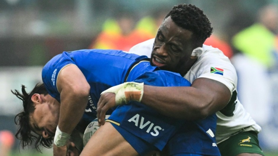 South Africa captain Siya Kolisi (R) makes a tackle during a tour victory over Italy last November.