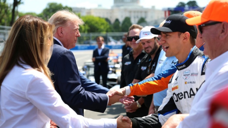 US President Donald Trump and First Lady Melania Trump, at left, greet IndyCar drivers before the start of the Freedom 250 Grand Prix on the streets of Washington