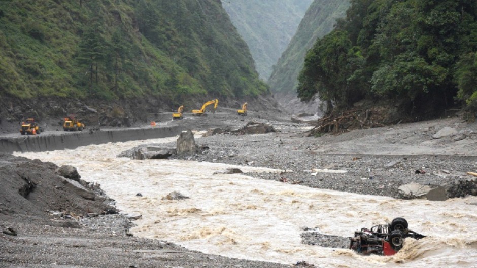 Excavators work in Tibet after disastrous flooding and landslides that struck the border with Nepal